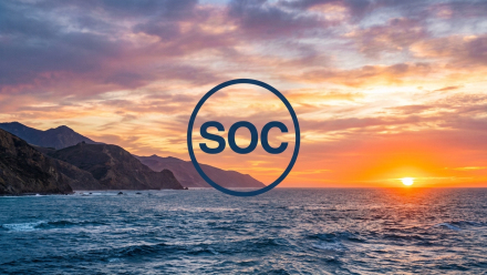 Sunset over California’s Pacific coastline with ocean waves and rugged cliffs, featuring a circular navy “SOC” graphic representing Sable Offshore Corp. (NYSE: SOC).