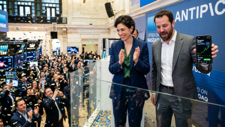 Illustration of an AI company’s stock market debut, with two executives celebrating above a crowded trading floor and a smartphone displaying a rising stock chart.